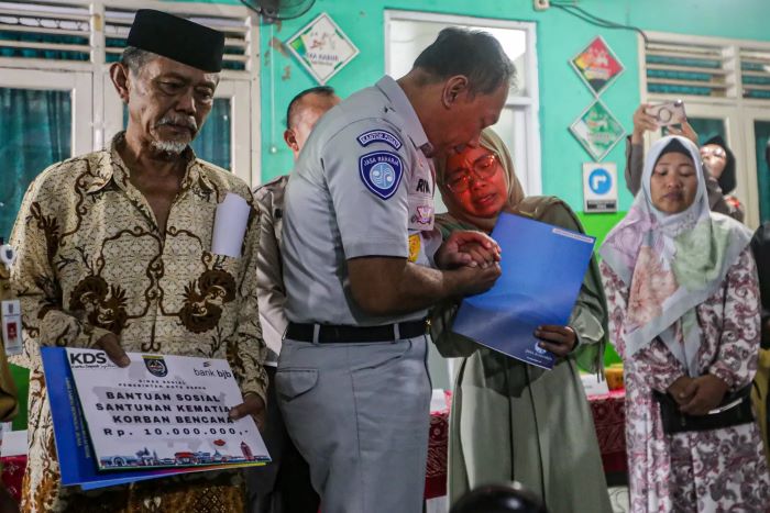 Caption Foto : Direktur Utama Jasa Raharja memberikan santunan simbolis kepada ahli waris korban