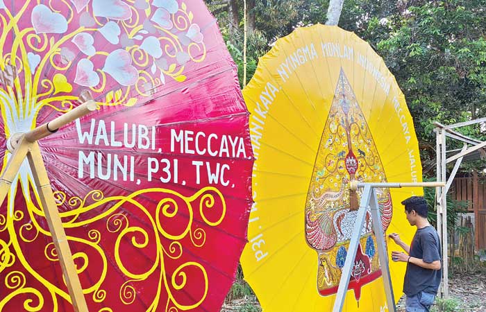 ARTISTIK: Seorang pemuda di Dusun Ngaran II, Borobudur melukis dengan media payung. Nantinya, payung itu akan dimanfaatkan sebagai perlengkapan perayaan Waisak 2568 BE/20