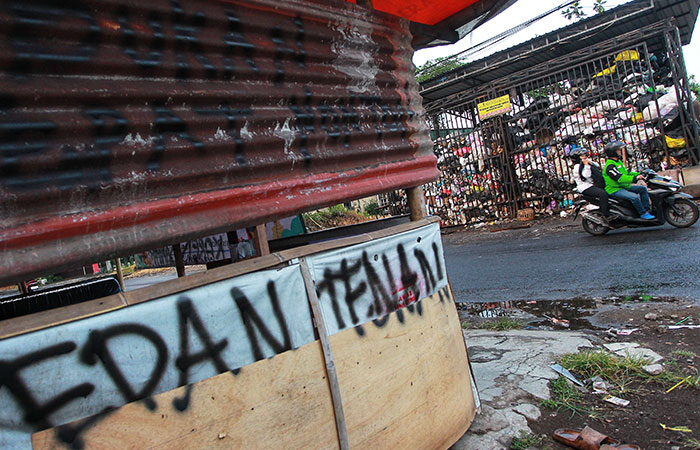 MENGGUNUNG: Pengguna jalan melintas di depan depo sampah Pengok, Gondokusuman, Kota Jogja, Jumat (17/5). Warga setempat merasa terganggu akibat bau tak sedap akibat tumpukan sampah