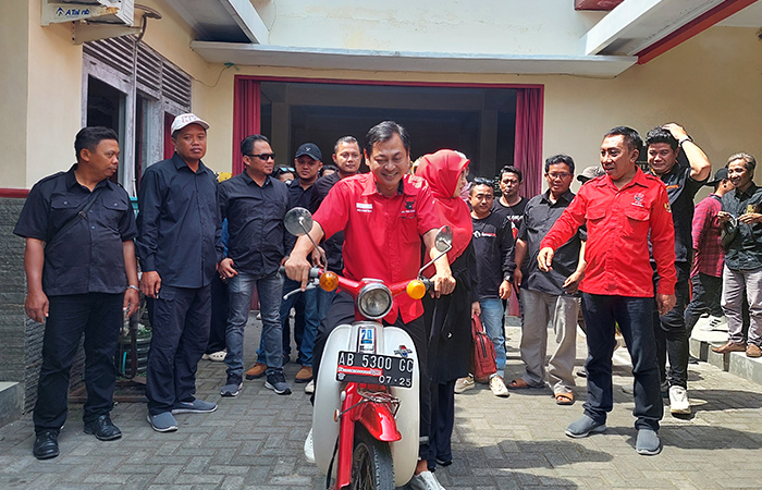 JADI NYALON: Novida Kartika Hadi menyerahkan formulir pendaftaran Pilkada bersama istrinya menggunakan motor antik ke DPC PDIP Kulon Progo (19/5).