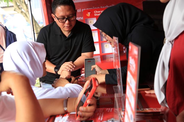 Customer service membantu salah satu calon jamaah haji melakukan aktifasi paket data di Booth Telkomsel