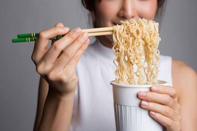 lustrasi seseornag yang makan Mie instan.