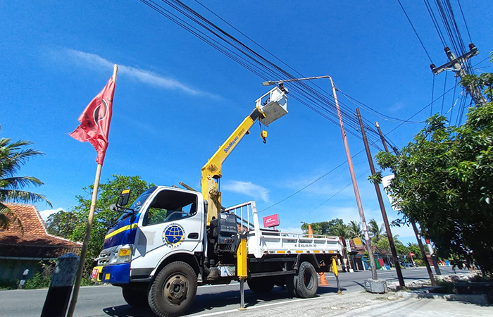 Petugas melakukan perawatan pada LPJU di ruas jalan kabupaten.