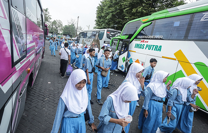 Siswa-siswi SMP dari Ciamis kembali menuju bus usai melakukan kunjungan wisata ke Taman Pintar di Parkiran Bus Senopati, Ngupasan, Gondomanan, Jogja, Jumat (24/5).