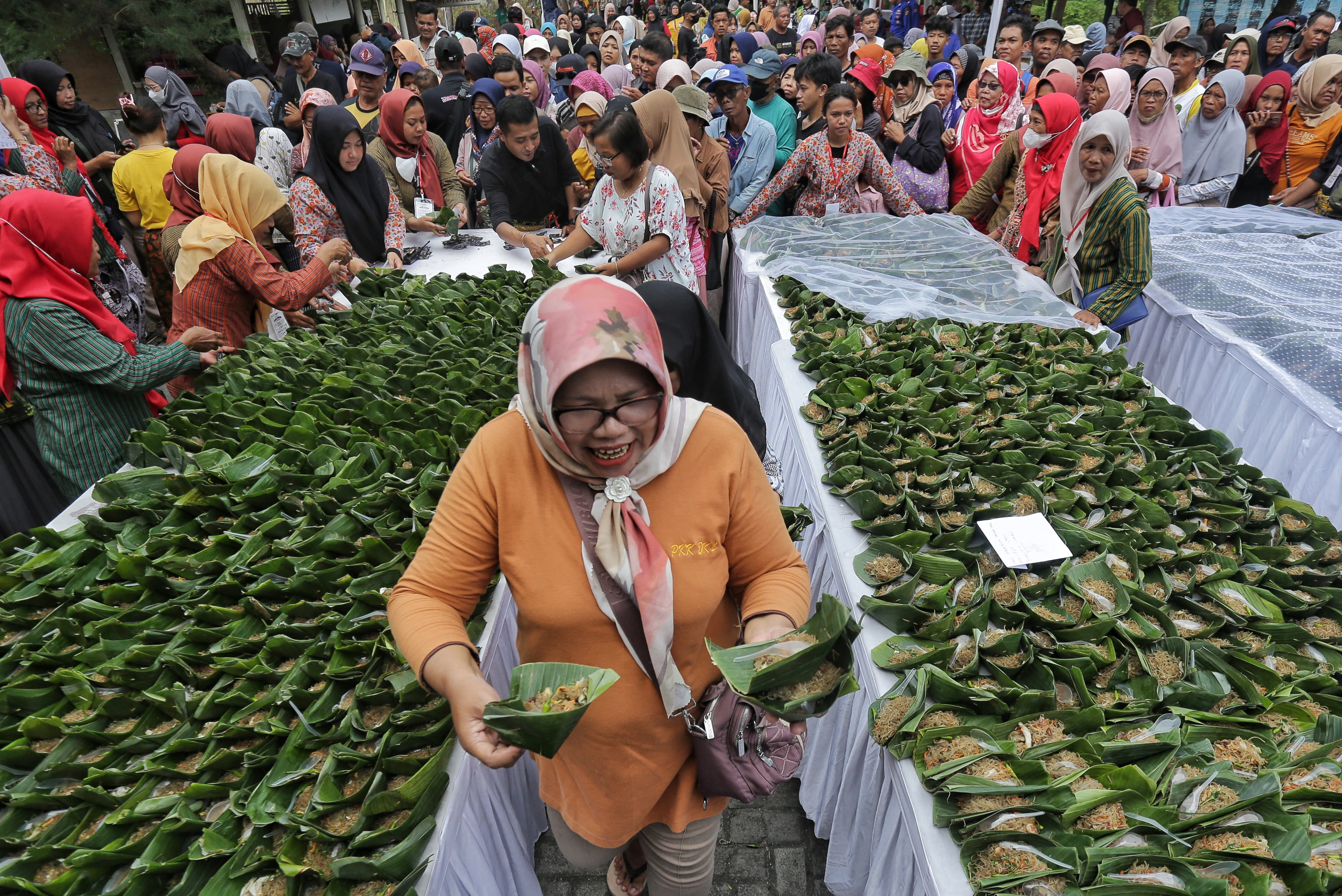 MAKANAN KHAS BANTUL- Pengunjung membawa mi lethek yang dibagikan saat pencatatan rekor MURI sajian mi lhetek terbanyak di kawasan Pantai Baru, Srandakan, Bantul, kemarin (25/5). (elang kharisma)