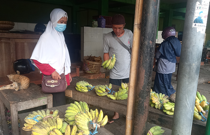 TEKUN: Haryani istri Mujiyono di lapak pisang mereka di Pasar Giwangan.