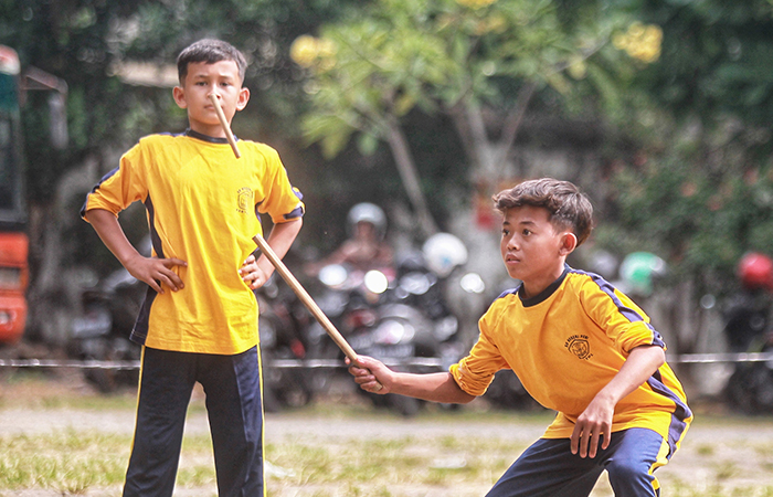 LATIH SPORTIVITAS: Pelajar tingkat SD mengikuti lomba permainan tradisional Benthik dalam acara perayaan Warisan Budaya Takbenda (WBTb) bertajuk Ajur Ajer Mbanyu Mili, di Ndalem Pakuningratan.