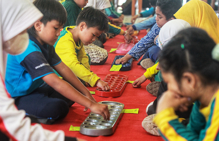 Pelajar tingkat SD mengikuti lomba permainan tradisional Dakon dalam acara perayaan Warisan Budaya Takbenda (WBTb) bertajuk Ajur Ajer Mbanyu Mili, di Ndalem Pakuningratan, Kota Jogja, Rabu (29/5).