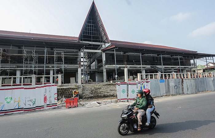 TAK SESUAI TARGET: Pengendara motor  melintas di depan proyek revitalisasi  Pasar Godean, Sleman, Rabu (29/5).  Proyek revitalisasi pasar yang dinaungi  pemerintah pusat melalui BPPW DIY.