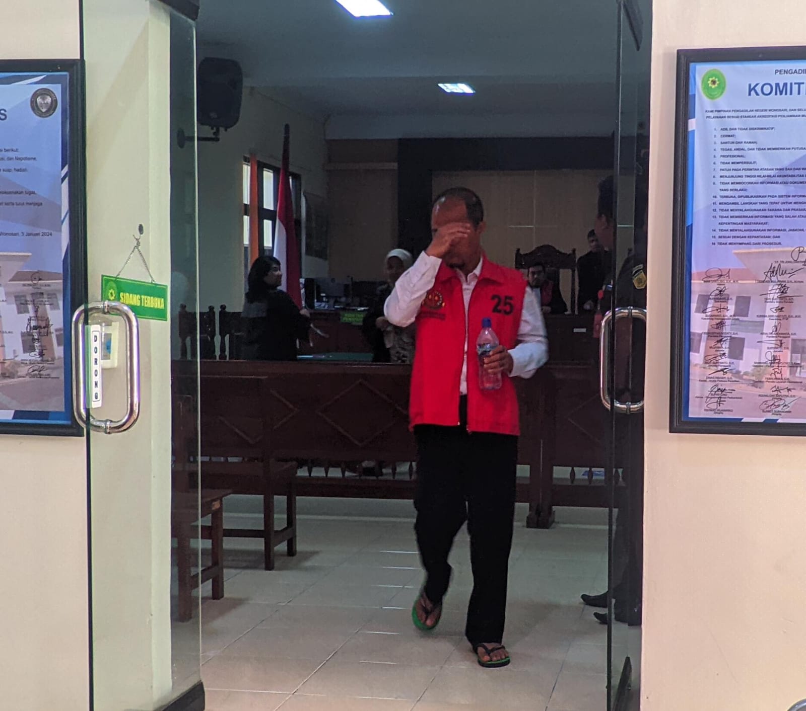 Terdakwa STP menutup wajah saat keluar dari Ruang Sidang Garuda, PN 1 Wonosari, Kamis (30/5) siang.