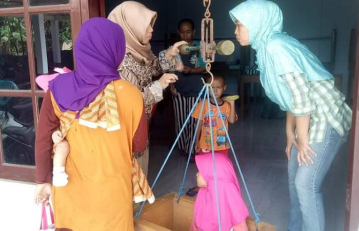 POSYANDU: Kader posyandu di bawah binaan Puskesmas Kebumen II sedang mengecek bobot balita menggunakan timbangan dacin.