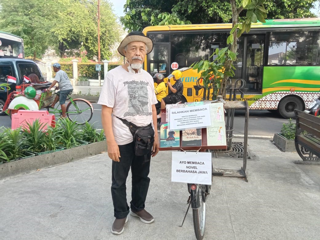 Bambang Saparyono saat menjajakan bukunya berbahasa Jawa di Nol Kilometer Yogyakarta, Sabtu (1/6/2024) lalu.
