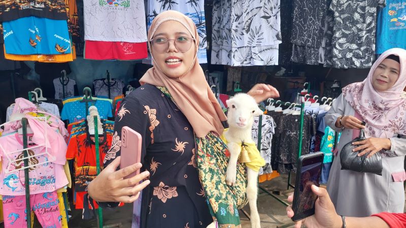 Irna menggendong Cemot sembari Live Streaming TikTok di Pantai Glagah, Kulon Progo menarik perhatian pengunjung sekitar.