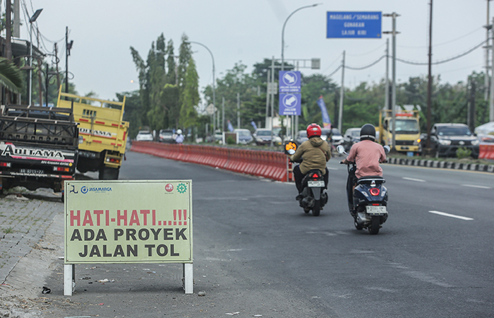 PENANDA: Papan penanda adanya proyek pembangunan tol terpasang di ring road utara, Kronggahan, Gamping, Sleman Senin (10/6).