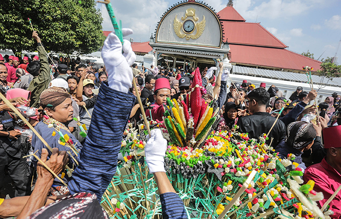 Abdi dalem Kraton Yogyakarta membagikan uba rampe gunungansaat Grebeg Besar di halaman Masjid Gedhe Kauman, Jogja, Selasa (18/6).&nbsp;