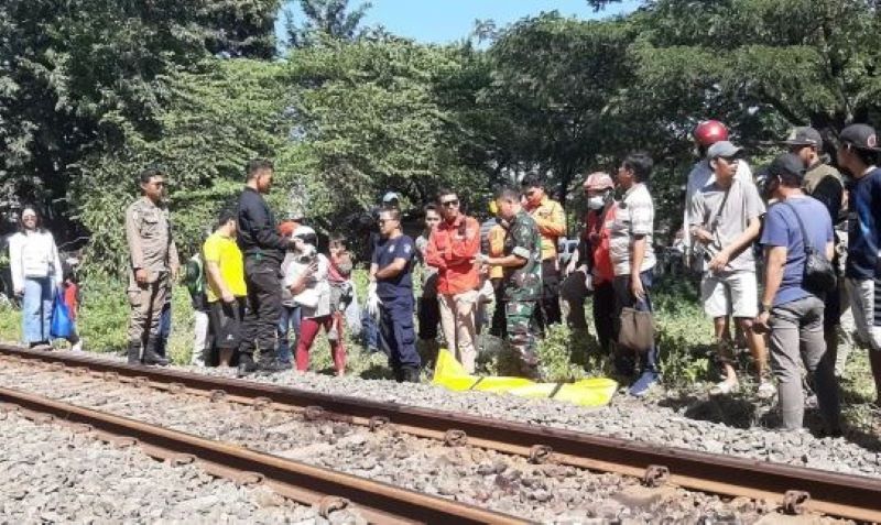 Petugas mengevakuasi jenazah korban tertabrak kereta api
