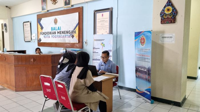 Foto petugas Balai Pendidikan Menengah Kota Jogjakarta saat membantu proses pendaftaran siswa yang terkendala
