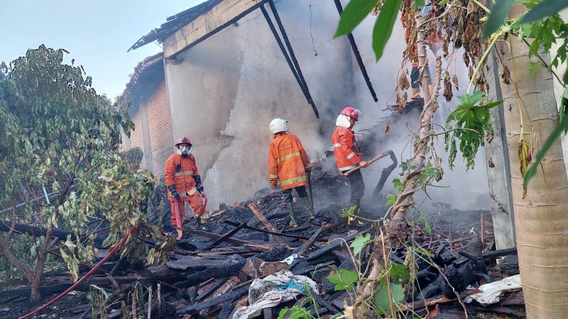 TELEDOR: Petugas Damkar memadamkan api yang membakar tumpukan kayu.&nbsp;