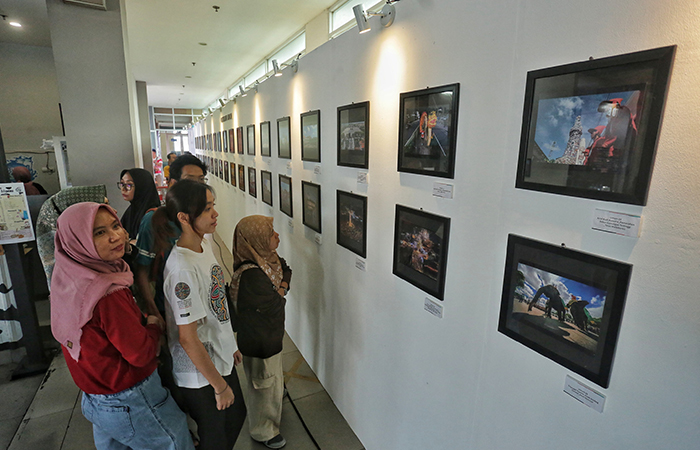 Pengunjung mengamati karya foto yang dipajnag saat pameran foto jogja dan festival film kampung di Rooftop Pasar Prawirotaman, Jogja, Jumat (21/6). ELANG KHARISMA DEWANGGA/RADAR JOGJA