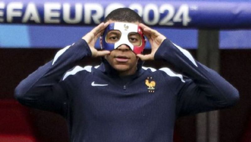 Kylian Mbappe pamerkan topeng dengan tiga warna yang akan dipakai, namu dilarang UEFA (Sathiri Kelpa/Anadolu via Getty Images)