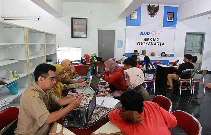 Petugas melayani calon siswa baru saat mencari informasi terkait Penerimaan Peserta Didik Baru (PPDB) tingkat SMA/SMK, di SMK Negeri 2 Kota Jogja,(24/6).GUNTUR AGA TIRTANA/RADAR JOGJA