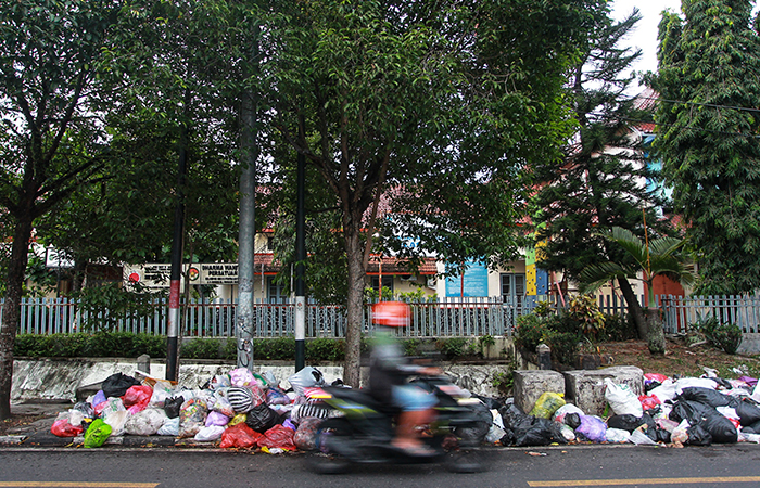 Pengguna jalan melintas di dekat tumpukan sampah di trotoar Jalan Wolter Monginsidi, Kota Jogja, (25/6).&nbsp; GUNTUR AGA TIRTANA/RADAR JOGJA