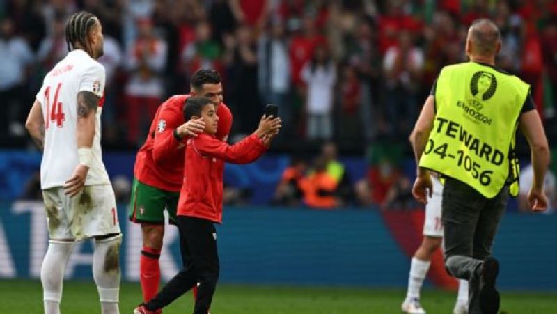 Seorang bocah menerobos barikade keamanan demi mendapatkan swafoto bersama Cristiano Ronaldo (Patricia De Melo Moreira/AFP via Getty Images)