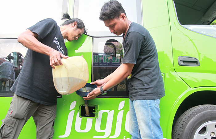 Ketua Yayasan Get Plastic Indonesia Dimas Bagus Wijanarko (kiri) mengujicoba dengan menuang BBM jenis solar hasil pengolahan sampah plastik ke shuttle wisata Si Thole, di Ngabean, Kota Jogja, Kamis.