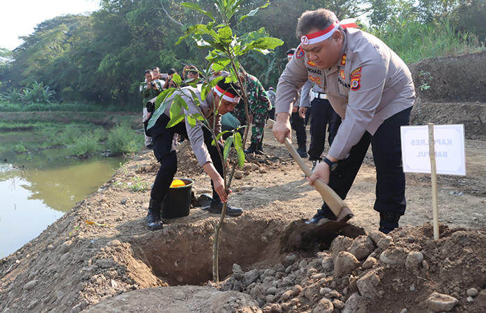 Kapolres Bantul AKBP Michael R Risakotta saat melakukan penanaman pohon di bantaran Sungai Progo di Dusun Trucuk, Kalurahan Triwidadi, Pajangan, Bantul, Kamis (27/6/2024). (Dok. Polres Bantul)