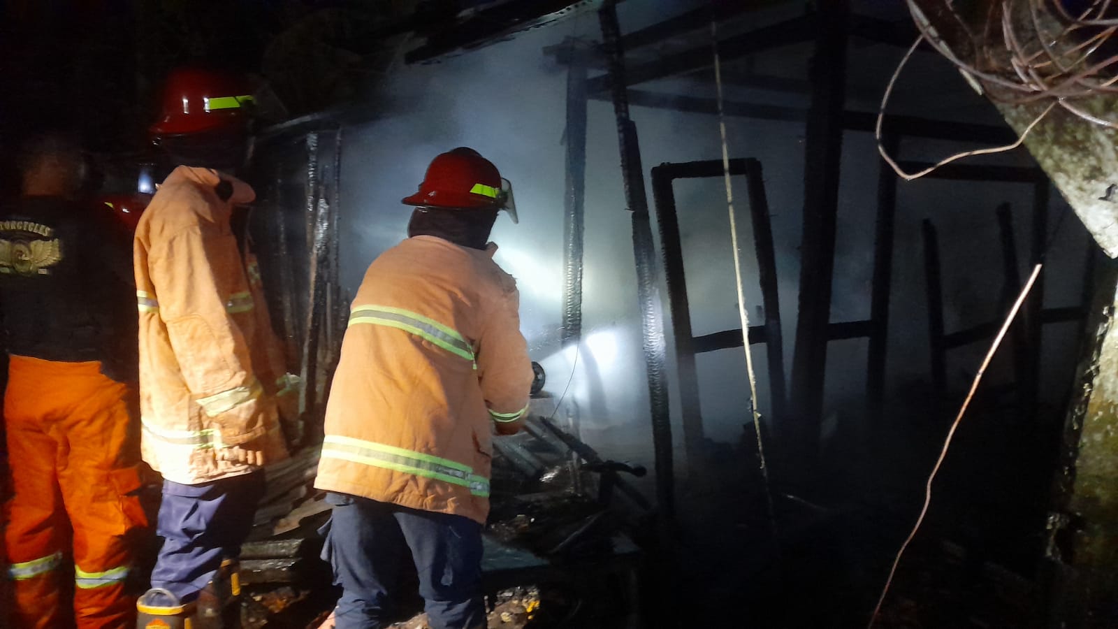 Petugas pemadam kebakaran berupaya memadamkan api yang melahap rumah jenis limasan, di Padukuhan Wiyoko Tengah, Kalurahan Plembutan, Playen, Gunungkidul, Minggu