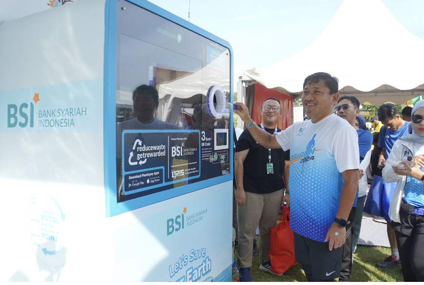 Wakil Direktur Utama BSI Bob Tyasika Ananta saat mencoba menukarkan botol plastik Reverse Vending Machine (RVM) yang terpasang di Race Village Area Candi Prambanan pada gelaran Mandiri Jogja Marathon