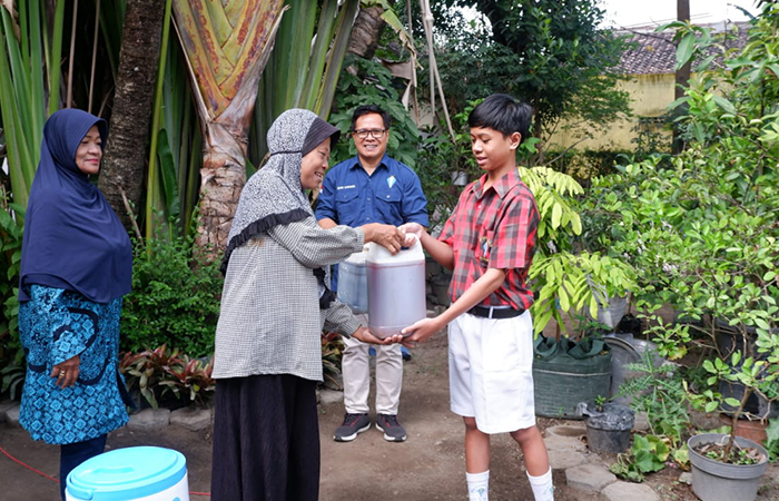MANFAAT - Siswa SMP Stella Duce menyerahkan caran pembersih hasil prodak eco enzim kepada warga sekitar sekolah belum lama ini.