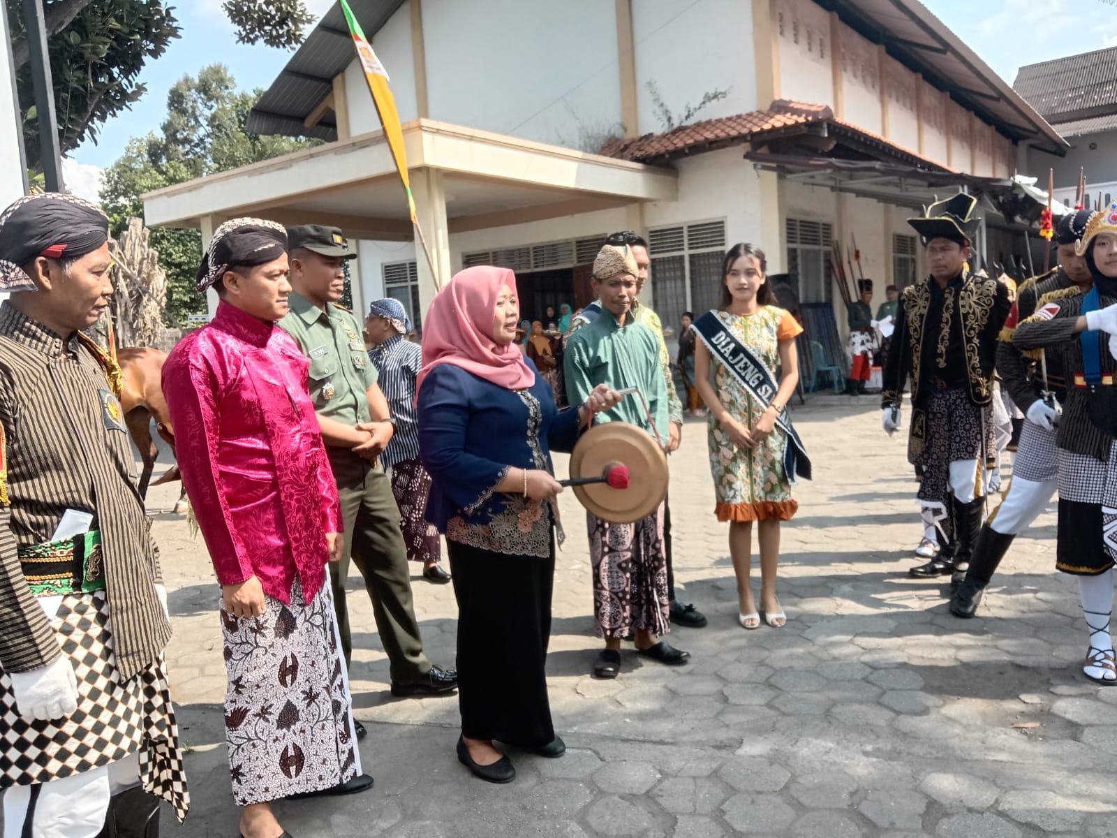 MERAKYAT: Bupati Sleman Dra Hj. Kustini Sri Purnomo memukul bendhe sebagai tanda dimulainya kirab gunungan Ki Ageng Singokerti di Grumbul Gede, Selomartani, Kalasan, Minggu (7/7/2024).