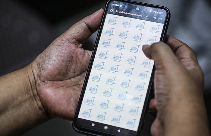 Warga menunjukan laman dukcapil Sleman online yang tidak dapat diakses di kawasan Prambanan, Sleman, Kamis (11/7). Layanan online disdukcapil Sleman tidak dapat digunakan karena dalam perbaikan fitur.