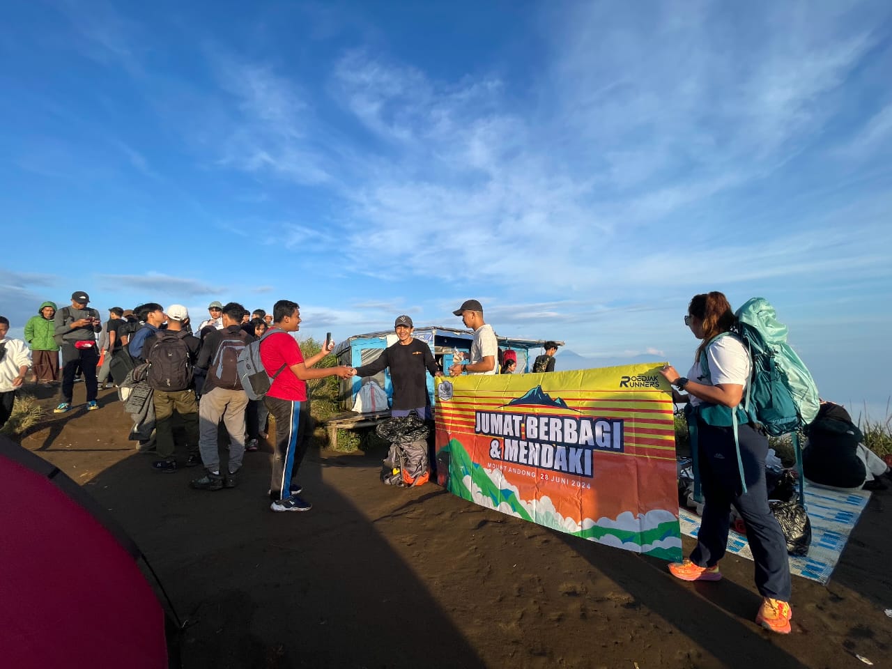 SALING BERBAGI: Beberapa orang dari lintas generasi membagikan nasi bungkus, jajanan, hingga stiker dan gantungan kunci kepada para pendaki di Gunung&nbsp;Andong.