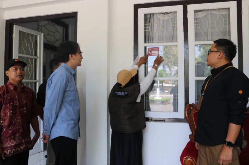 Pantarlih saat menempelkan stiker di salah satu rumah warga di Purworejo sebagai tanda pemilik rumah tersebut sudah dicoklit beberapa waktu lalu.