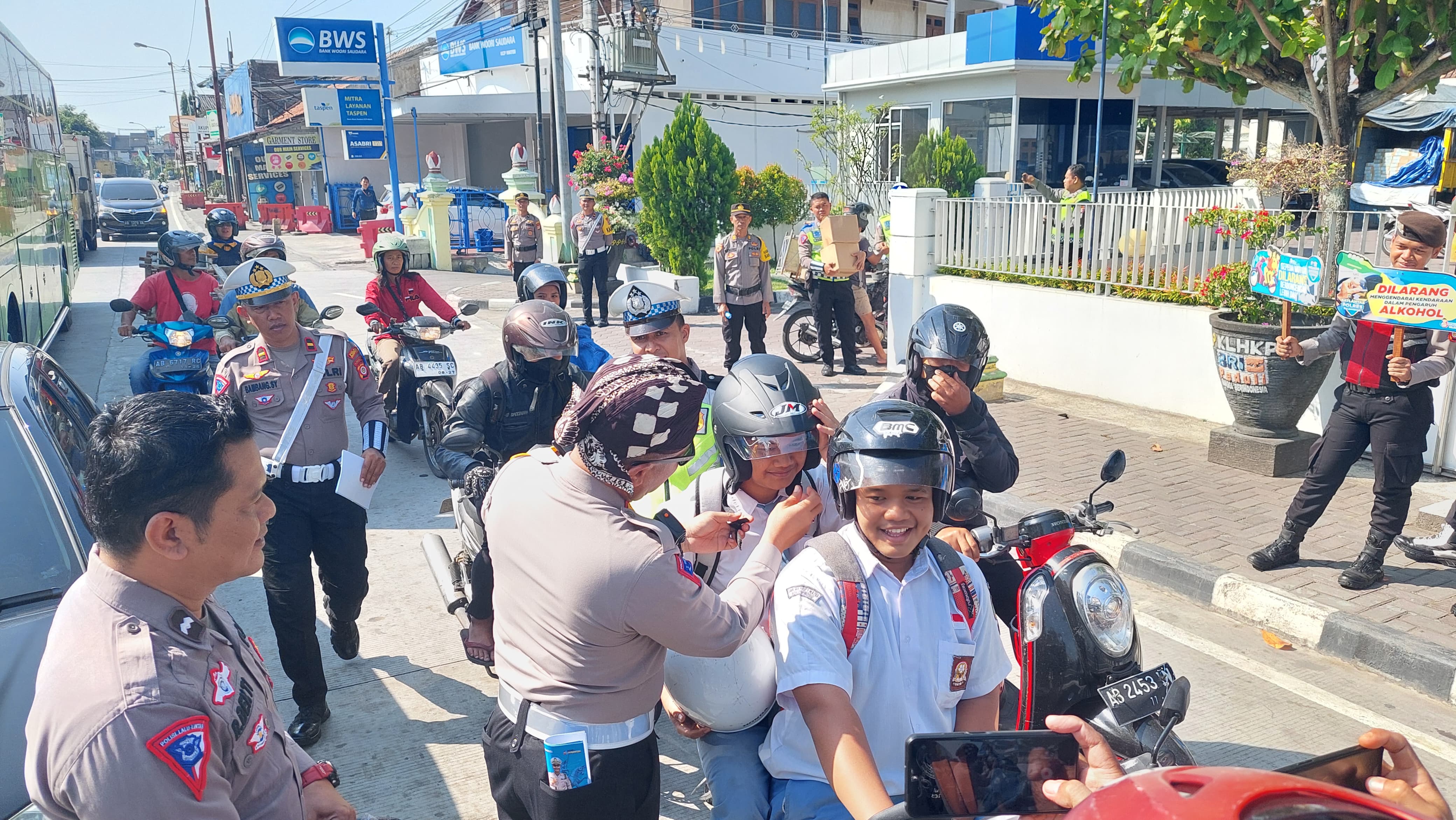 Kasatlantas bagikan helm kepada pengendara anak sekolah.