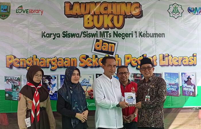 KOLEKSI KARYA : Kepala MTsN 1 Kebumen (baju batik) menyerahkan buku hasil karya siswa kepada Kepala Disarpus Kebumen Sigit Dwi Purnomo. (M Hafied/Radar Jogja)