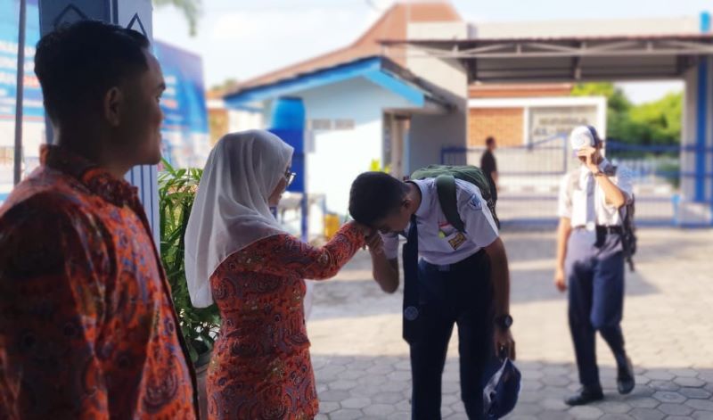 SOPAN - Sebelum KBM dimulai terlihat sejumlah murid SMP Angkasa Adisucipto menyalami para tenaga pendidik pada Rabu (24/7/2024).&nbsp;