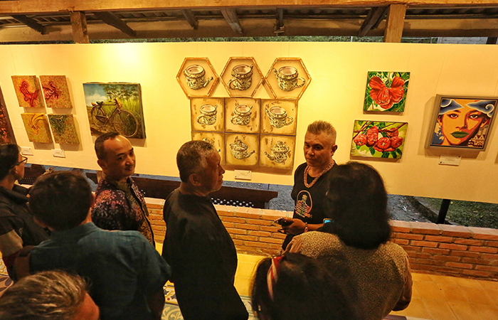 Pengunjung Mengamati Karya Lukisan yang dipamerkan saat Pameran Seni Rupa