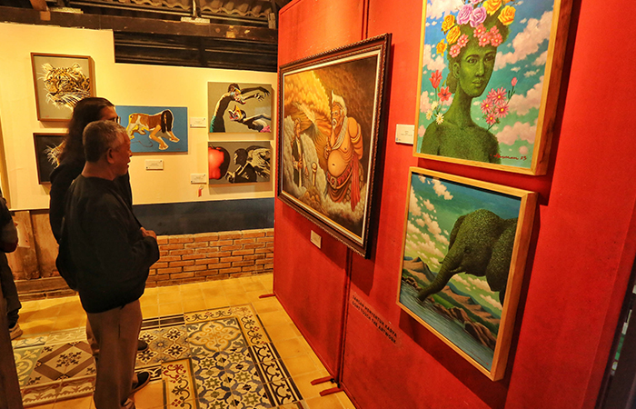 Pengunjung Mengamati Karya Lukisan yang dipamerkan saat Pameran Seni Rupa