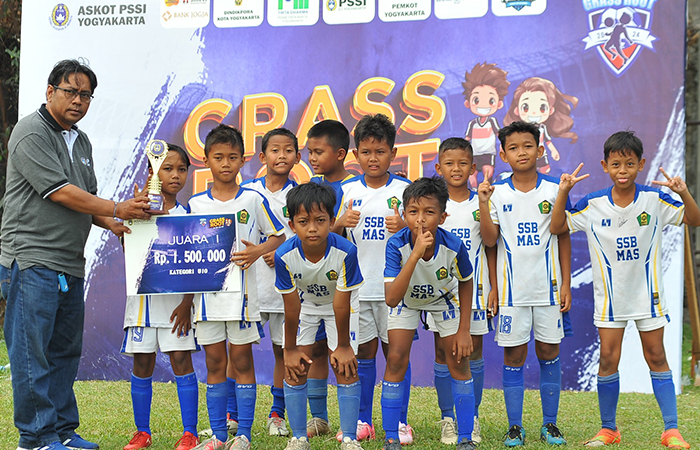 PRESTASI: Sekertaris Umum Askot PSSI Kota Jogja Ari Santoso saat menyerahkan piala juara KU-10 tahun kepada tim SSM MAS Rajawali.Humas Askot PSSI Kota Jogja