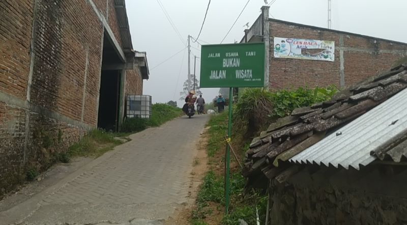 DIPASANG PAPAN: Warga Prampelan, Adipuro, Kaliangkrik resmi menutup akses jalan untuk wisatawan karena dinilai mengganggu aktivitas petani.