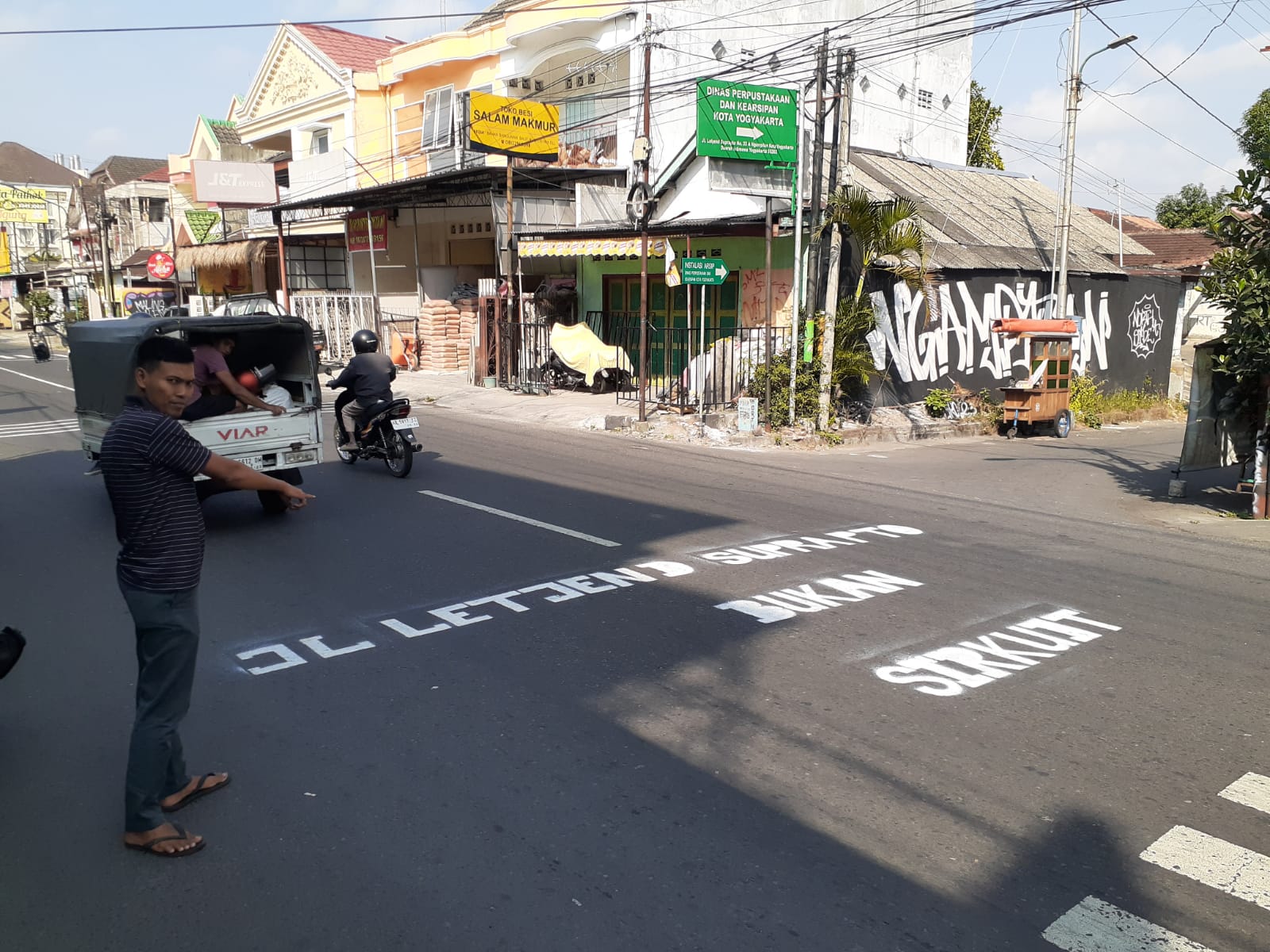 Salah seorang warga saat menunjukkan tulisan protes Jalan Letjen Suprapto yang kerap dijadikan lokasi kebut-kebutan pada Selasa (30/7/2024).  (IWAN NURWANTO/Radar Jogja)