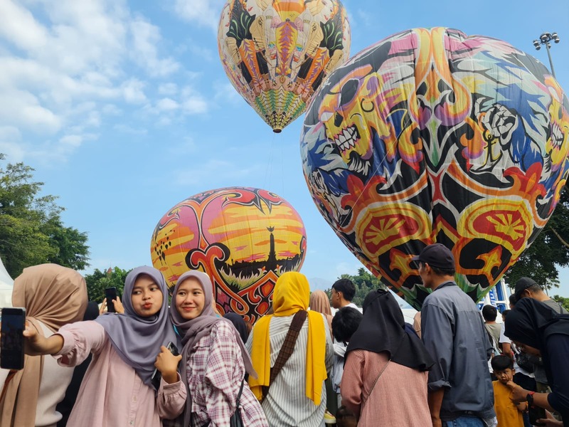 Pengunjung selfi disela kegiatan festival balon udara di Alun-alun Kota Magelang, Sabtu (3/8/2024).