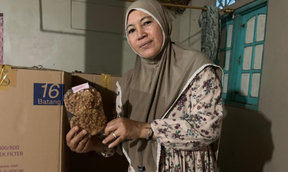 Keterangan Salah satu produsen peyek di Dusun Pelem Madu Kustinah saat berfoto dengan produk peyeknya.Rizky Wahyu/Radar Jogja
