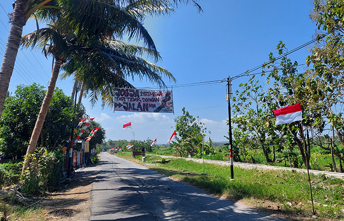 BENTUK PROTES: Baner bertuliskan penggambaran jalan rusak menghias ruas Jalan Cerme-Demangan Minggu(4/8).ANOM BAGASKORO/RADAR JOGJA