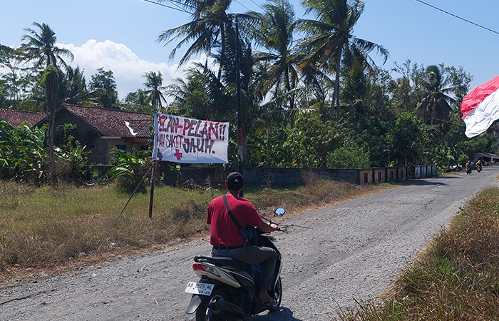 BENTUK PROTES: Baner bertuliskan penggambaran jalan rusak menghias ruas Jalan Cerme-Demangan Minggu(4/8).ANOM BAGASKORO/RADAR JOGJA