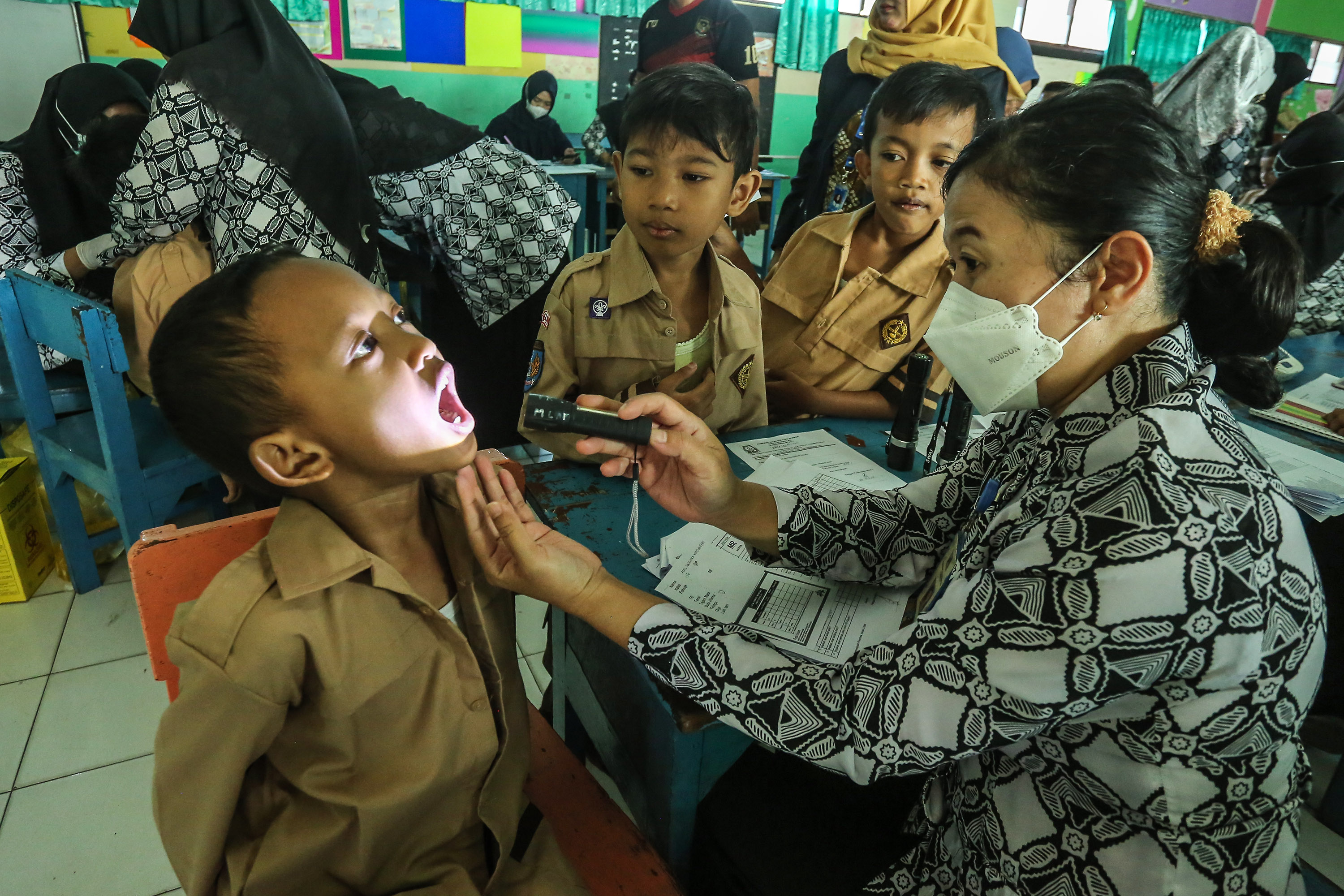 Siswa-siswi mengikuti skrining kesehatan dan vaksinasi di SDN 1 Sinduadi, Mlati, Sleman, Jumat (9/8). Dinas kesehatan Sleman menggelar program bulan imunisasi anak nasional (BIAS) yang diadakan serentak bulan agustus dan november. pemberian imunisasi dasa
