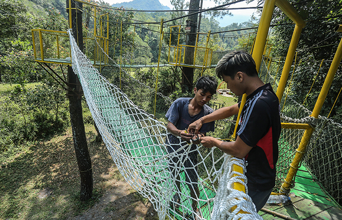 Pekerja menyelesaikan pemasangan jaring pengaman di kawasan wisata alam Plunyon, Umbulharjo, Cangkringan, Sleman, Rabu (14/8).